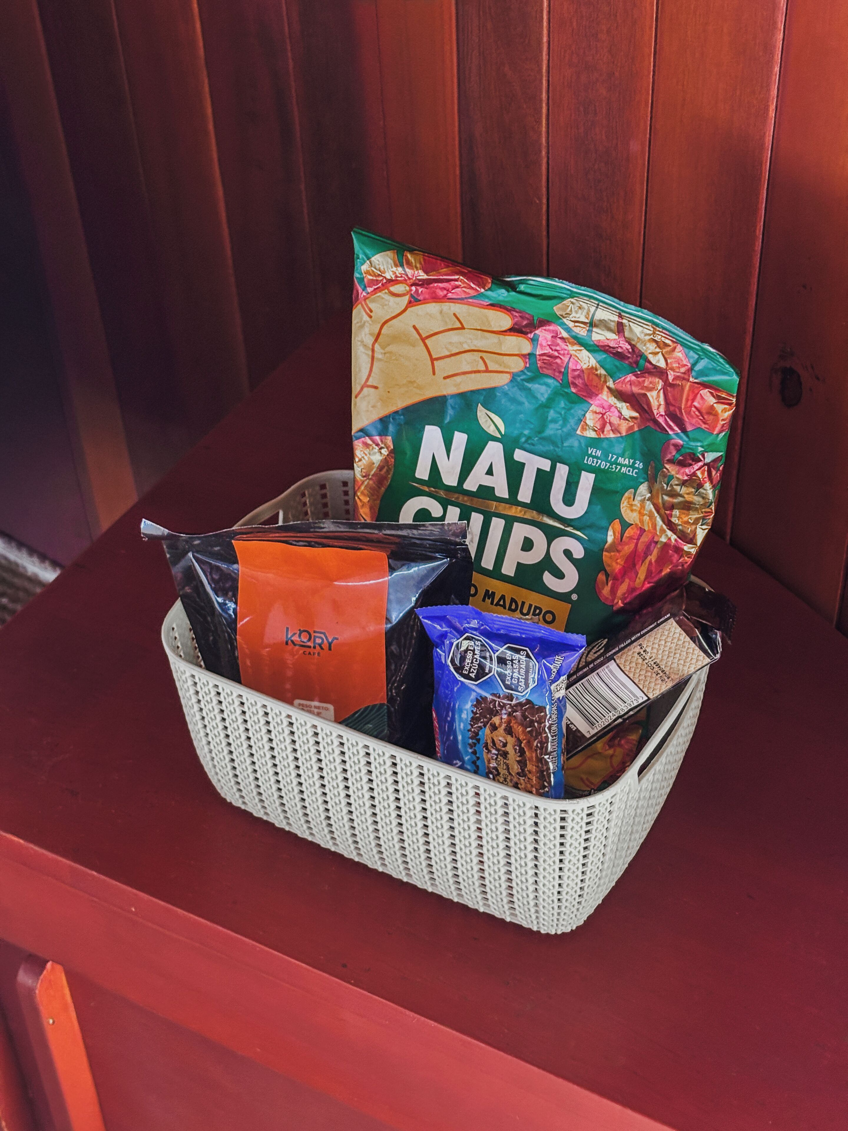 Manden met snacks en een zak Natu Chips op een rode stoel.