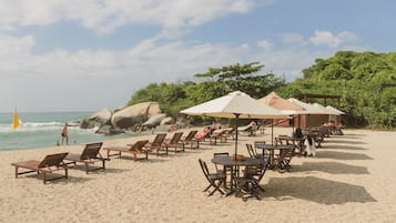 Di pantai, pasir putih, kerusi lepak pantai, payung