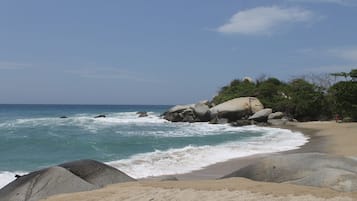 On the beach, white sand, sun loungers, beach umbrellas