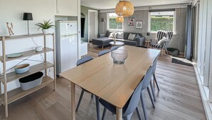 Une cuisine moderne avec une table à manger, des chaises et un réfrigérateur.