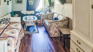 Ein gemütliches Zimmer mit Bett, Sofa, kleinem Tisch und Schrank.