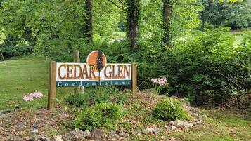 A sign for Cedar Glen Condominiums surrounded by lush greenery.