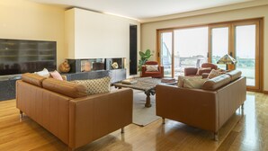 A spacious living room with a large sofa set, a coffee table, and a fireplace. - Estoril Queen's Apartment by CadenzaLux (Estoril)