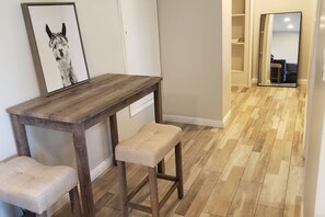 Ein Flur mit einer hölzernen Bank und einem gerahmten Bild an der Wand.
