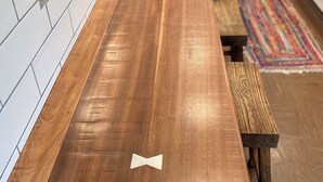 Une cuisine dotée d’un long comptoir en bois, d’un dosseret carrelé blanc et d’un tapis coloré sur le sol.