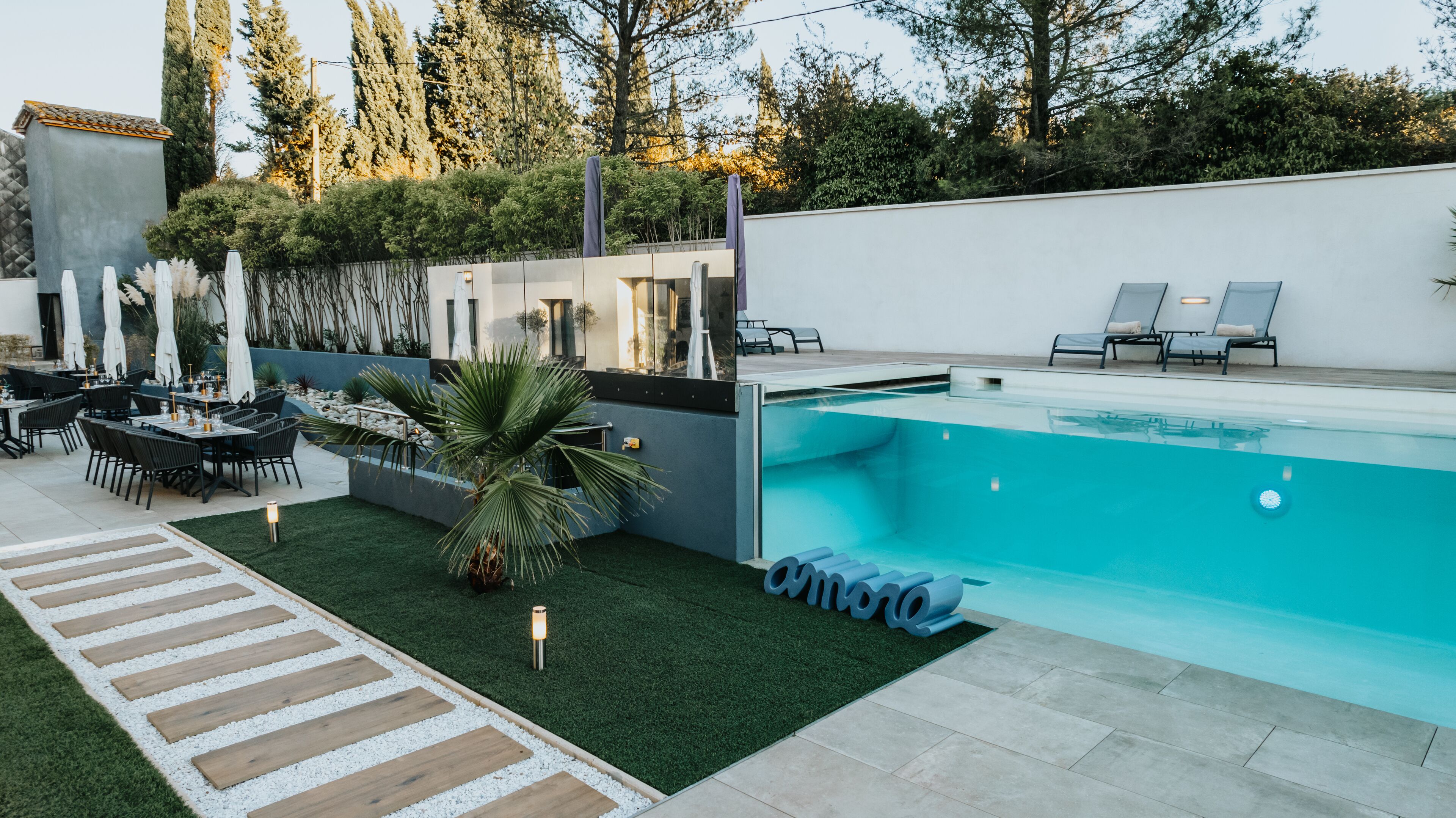 A modern outdoor pool area with a dining setup and lounge chairs.