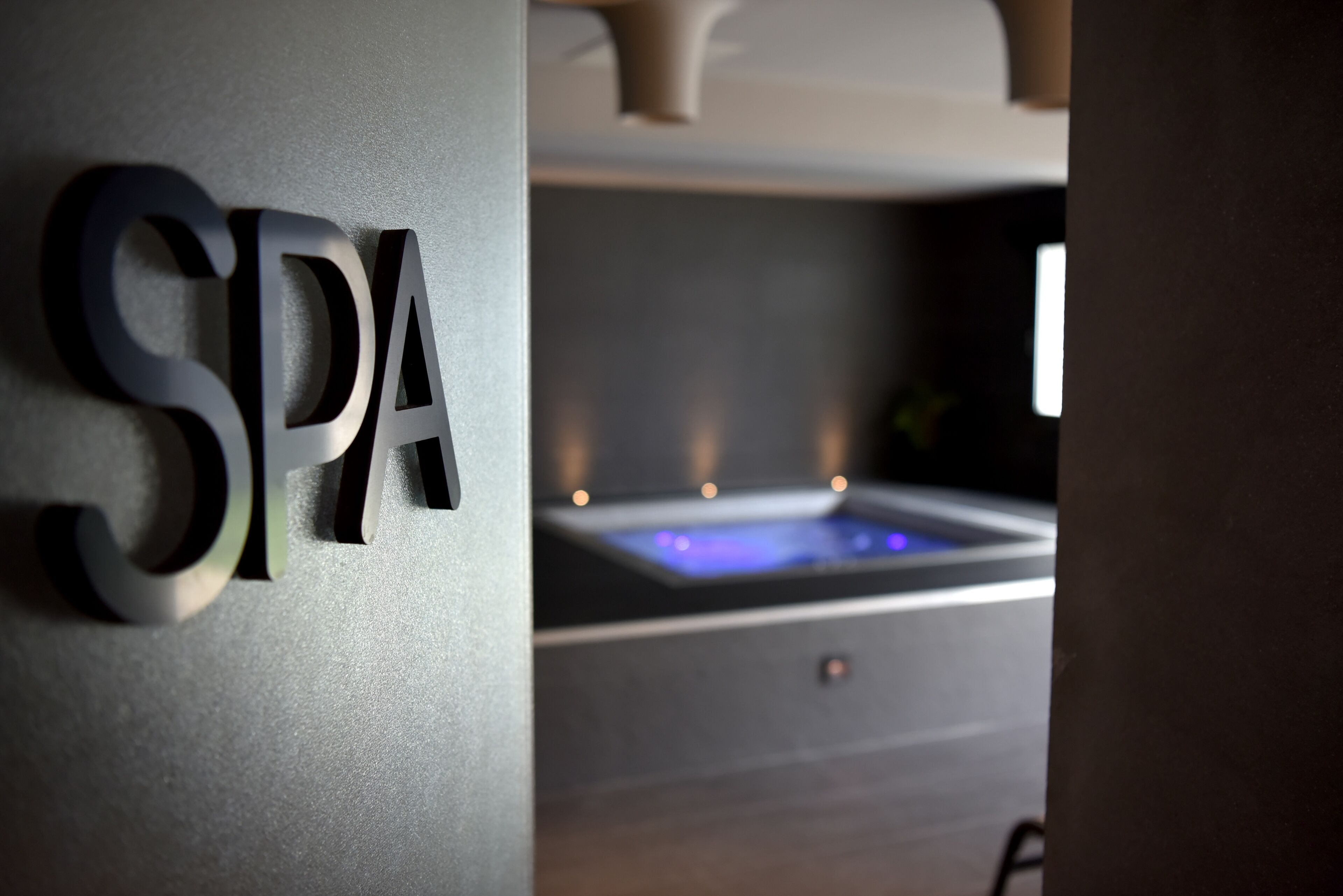 A spa sign with a water feature in the background.