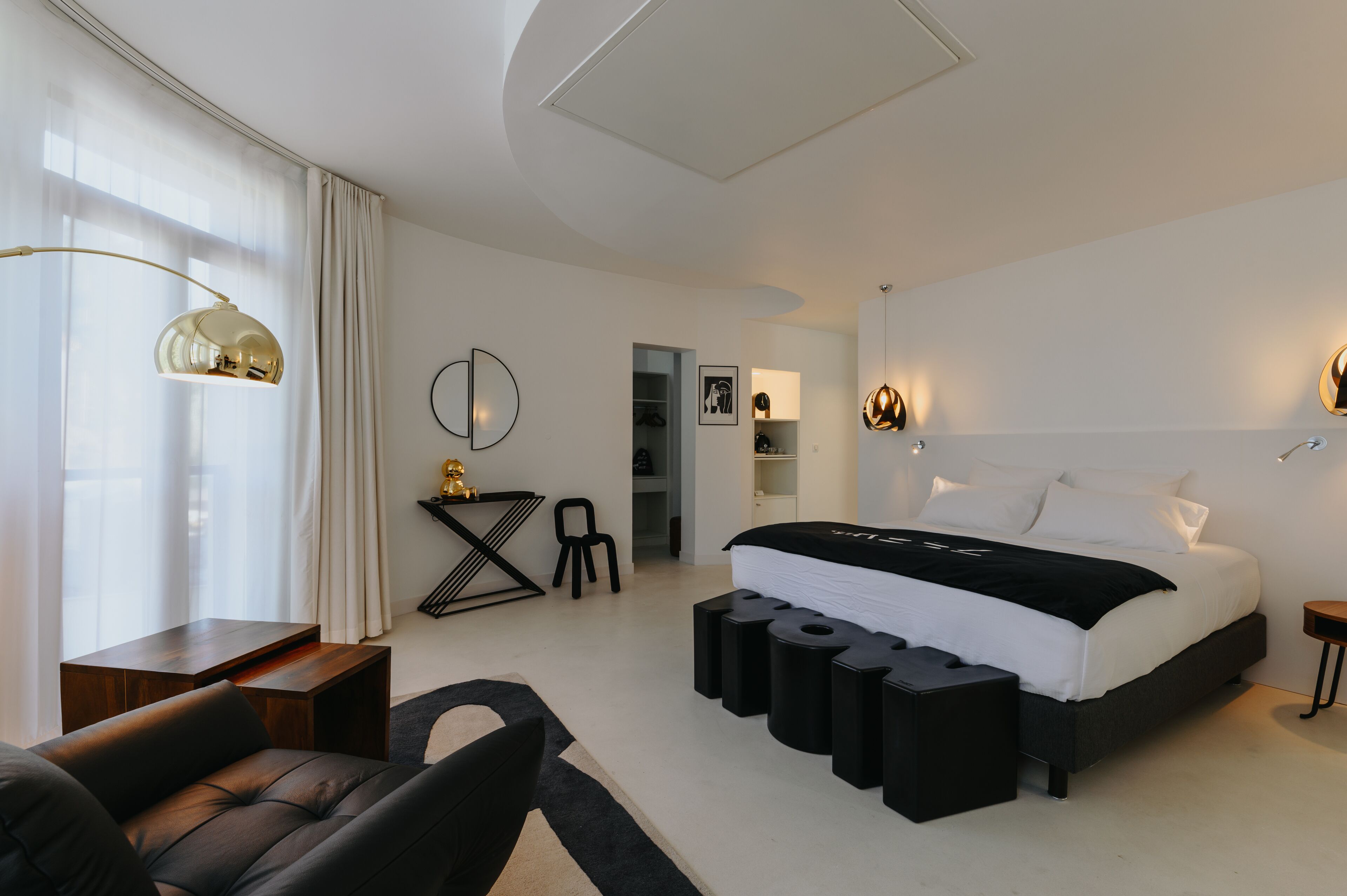 Une chambre moderne avec un grand lit, un bureau, une chaise et un canapé.