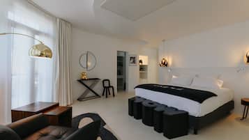 Une chambre moderne avec un grand lit, un bureau, une chaise et un canapé.