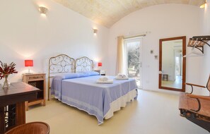 A bedroom with a bed, bedside tables, a desk, a chair, a mirror, and a view of the outdoors. - Cozy home in Cisternino (Cisternino)