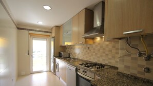 A modern kitchen with granite countertops, stainless steel appliances, and wooden cabinets.