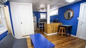 A room with a blue table, a bench, a wooden bar counter, and a mirror on the wall. - Moon Apartments  First Floor (#3) (Isla de Utila)