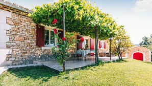 A stone house with a covered patio, red shutters, and a red door. - Amazing home in Lioux (Lioux)