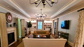 A living room with a sofa, a fireplace, a chandelier, and a television. - Oversized Country house, Quiet Retreat & Gathering space ~NEW !!!  (Ulster Park)