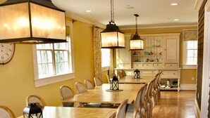 A dining area with a long wooden table and chairs, pendant lights, and a clock on the wall. - Oversized Country house, Quiet Retreat & Gathering space ~NEW !!!  (Ulster Park)