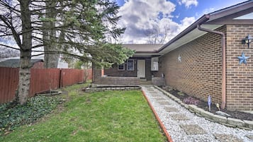 Enjoy a serene atmosphere in this single-story home surrounded by a lush lawn and a tree.