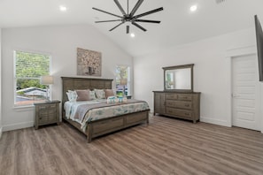 Relax in this spacious room with a large bed, nightstands, and a dresser with mirror.