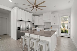 Enjoy cooking in this well-equipped kitchen with a central island, oven, and white cabinetry.