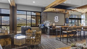 A lobby bar with a mountain view, modern furniture, and a stone accent wall. - Grand Colorado on Peak 8 Suite - Ski-in/out (Breckenridge)