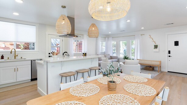 A modern kitchen with white cabinetry, a central island with stools, and pendant lighting. - Your wine country getaway! (Sonoma)