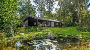 A cabin with a pond and lily pads, surrounded by trees and greenery. - 3 bedroom lovely home in Gilleleje (Gilleleje)