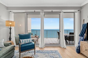 A balcony with a view of the sea, a blue chair, a wooden cabinet, and a lamp. - Lower early bird rates for Oct Nov and Dec. Princess 1505 awaits! (Panama City Beach)