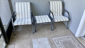 A seating area with two striped chairs and a bench, a window, and a tiled floor. - Cozy relaxation home in the heart of Cocoa (Cocoa)