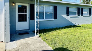 A single-story house with a front porch, a door, and a window with shutters. - Cozy relaxation home in the heart of Cocoa (Cocoa)