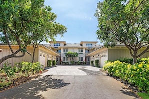 A residential building with a central courtyard, surrounded by trees and shrubs.