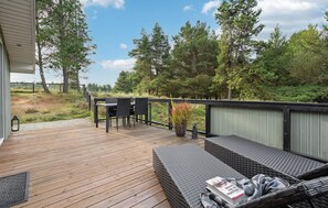 A wooden deck with outdoor furniture, a dining table, and chairs. - Amazing home in Rømø with WiFi (Rømø)