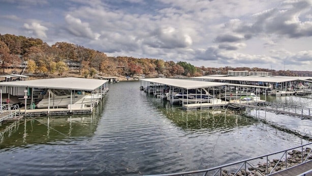 A marina with multiple docked boats and covered structures.