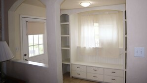 A room with a built-in bench, a window with a view, and a door. - Cheerful 3 bedroom Corner Cottage (Jasper)