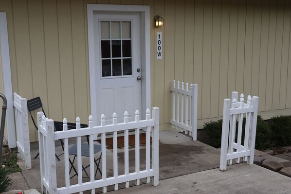 A house with a white door, a mailbox, and a white picket fence. - Cheerful 3 bedroom Corner Cottage (Jasper)
