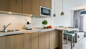 Eine moderne Küche mit Holzschränken, integriertem Mikrowellenherd und Pendelleuchten.