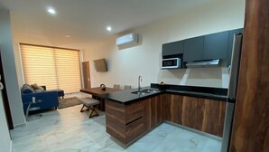 A modern kitchen with a wooden island, built-in microwave, and stainless steel appliances. - New 3-Bedrooms apartment close to the beach. (Mazatlan)