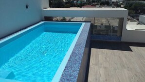 A rooftop swimming pool with a clear view of the cityscape in the background. - New 3-Bedrooms apartment close to the beach. (Mazatlan)