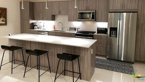 A modern kitchen with a large island, bar stools, stainless steel appliances, and pendant lighting.