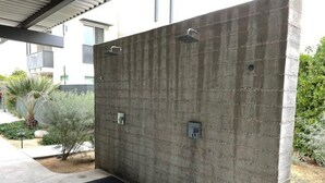 A concrete wall with two metal door handles and a small electrical box.