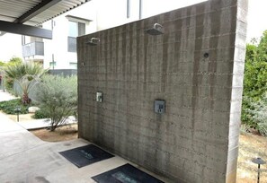 Eine Betonwand mit zwei Metallgriffen und einem kleinen Stromkasten.