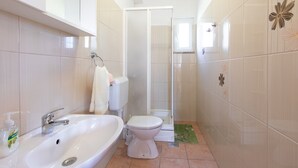 A bathroom with a sink, toilet, and shower.