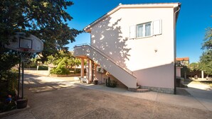 A two-story building with a covered patio and a basketball hoop.