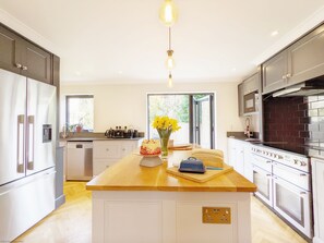 A modern kitchen with a central island, stainless steel appliances, and a view to the outdoors. - Steddles - Chichester  -  a town house that sleeps 8 guests  in 4 bedrooms (Chichester)