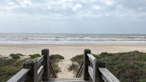 A wooden boardwalk leading to a sandy beach with the ocean in the background. - Livin' Lobster - New, Near Beach🌊🏖 , Sleeps 8, Pet Friendly🐶, 📍Central Location (Bolivar Peninsula)