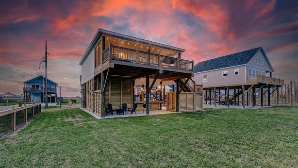 A two-story house with a balcony and a covered patio area. - Livin' Lobster - New, Near Beach🌊🏖 , Sleeps 8, Pet Friendly🐶, 📍Central Location (Bolivar Peninsula)