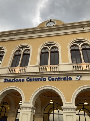 Ein Gebäude mit der Aufschrift 'Stazione Catania Centrale', das einen Bahnhof kennzeichnet.