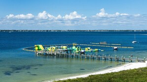 Un muelle con estructuras de juego coloridas y una playa arenosa.