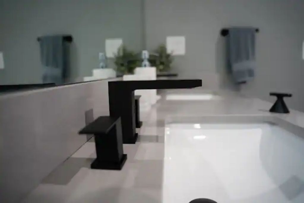 Een bad/douchecombinatie, een haardroger, handdoeken, zeep