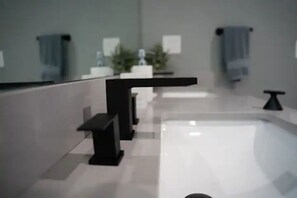 Een bad/douchecombinatie, een haardroger, handdoeken, zeep