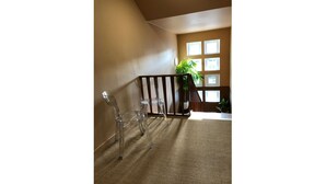 A room with a wooden railing, a clear glass table, and a potted plant near a window. - App*** 2/3 pers "Nuage" ☁️ Air-conditioned with garden (Lons-le-Saunier)
