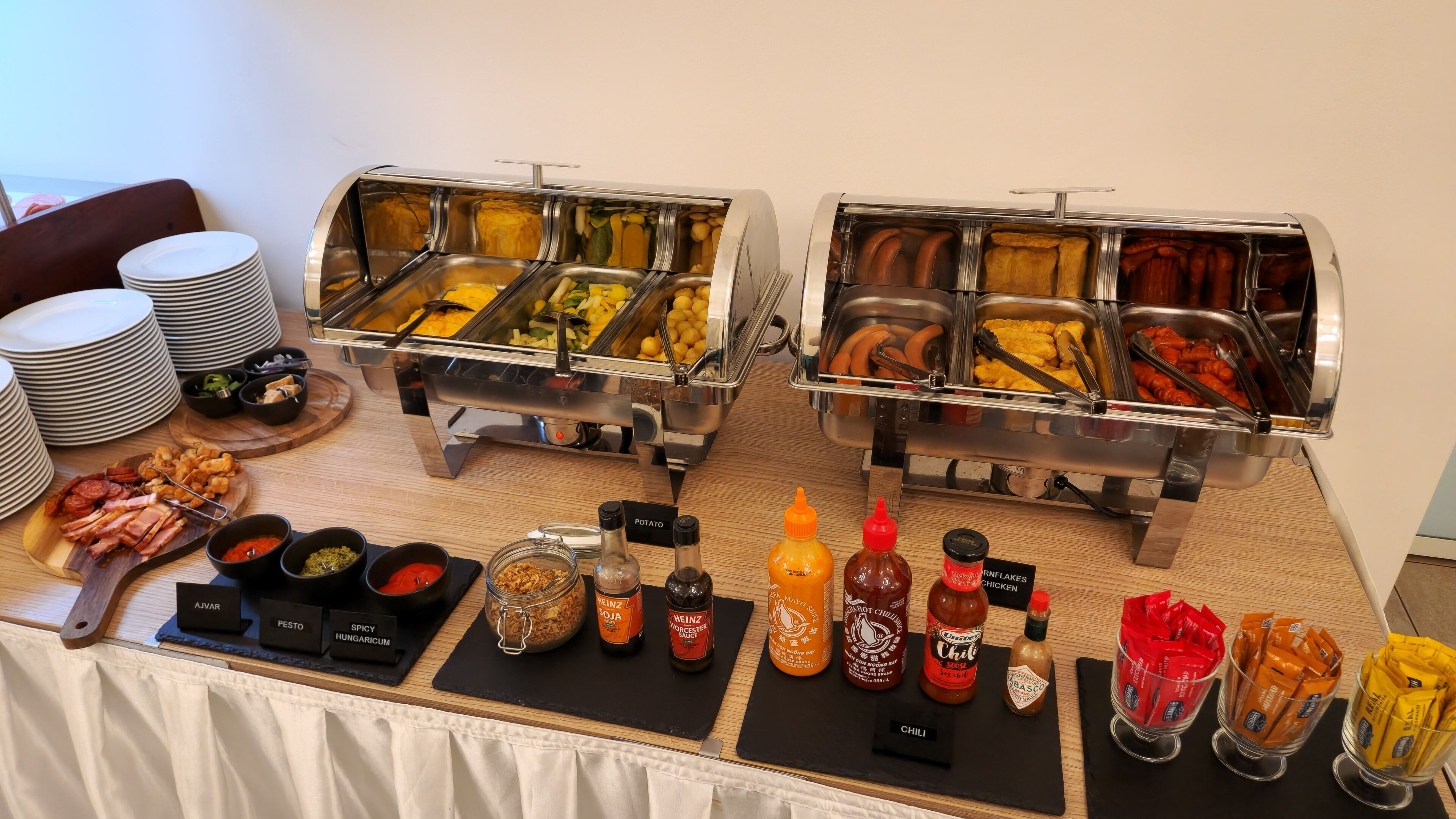 A buffet with multiple food stations, including a variety of meats, vegetables, and condiments.